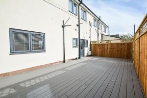 an empty patio with a wooden fence and a house at Luxury 2-Bedroom Formby Property in Formby