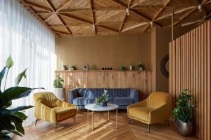 a living room with a couch and two chairs and a table at The Emerald in Prague