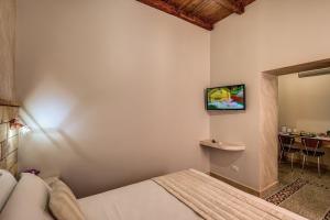 a bedroom with a bed and a tv on the wall at Colosseo Accomodation Room Guest House in Rome