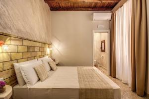 a bedroom with a bed and a brick wall at Colosseo Accomodation Room Guest House in Rome