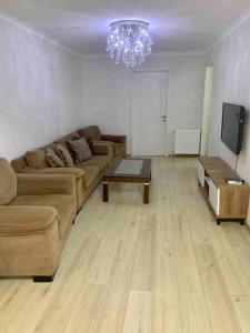 ein Wohnzimmer mit einem Sofa und einem Tisch in der Unterkunft Cozy Apartment in Tbilisi City
