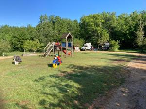 a park with a playground and a play structure at Camping Fargogne in Puygaillard-de-Quercy
