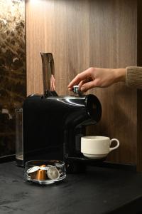 a person is pouring coffee into a coffee maker at KOPAONIK WOODSIDE 58,70 m2 FREE Parking in Kopaonik