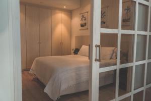 a bedroom with a bed and a sliding glass door at Japandi x Jungle Apartment in Cape Town