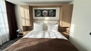 een slaapkamer met een bed met witte lakens en 2 kussens bij Prinsengracht Hotel in Amsterdam