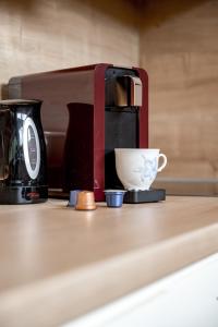 una macchinetta del caffè e una tazza su un bancone di Viktoria Sölden a Sölden