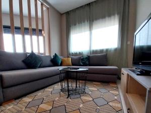 a living room with a couch and a table at Beautiful apartment next to airport Mohamed V in Derroua