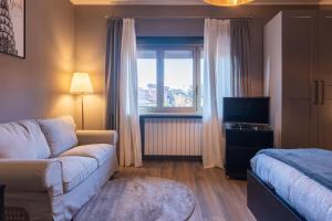 - un salon avec un canapé, un lit et une fenêtre dans l'établissement Villaggio Junior - bambnb, à Stupinigi