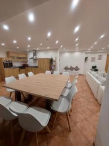 uma sala de conferências com uma mesa de madeira e cadeiras brancas em Apartment Kofelblick em Unterammergau