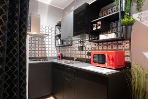 una cocina con armarios negros y un microondas rojo en una encimera en Villaggio Junior - bambnb, en Stupinigi