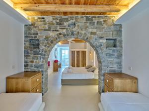 Pokój z 2 łóżkami i kamienną ścianą w obiekcie Zefi Hotel & Suites w mieście Nausa +37 zdjęć