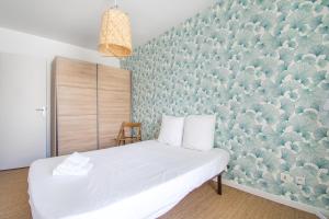 een slaapkamer met een wit bed en een groene muur bij Cosy T2 de 50 m² Centre-Ville avec Garage & Balcon in Nantes