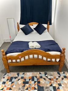 a bedroom with a wooden bed with towels on it at Cosy Home Stay in London