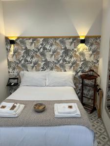 - un lit avec 2 serviettes et un bol de nourriture dans l'établissement EME SEVILLA TURISTICA, à Séville