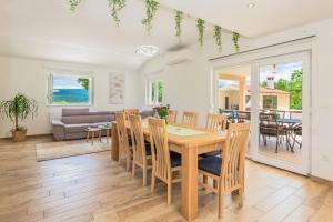 a dining room and living room with a table and chairs at Villa Patria with Media room, Private pool, Summer kitchen, Gym in Lovreć