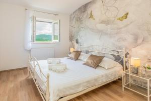 a bedroom with a bed and a wall with butterflies at Villa Patria with Media room, Private pool, Summer kitchen, Gym in Lovreć +42 photos
