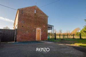 un edificio de ladrillo con una puerta en el costado en Gorgeous 2-bed Home in Lincoln by Renzo, Stunning Countryside Location, Free Parking!, en Stow