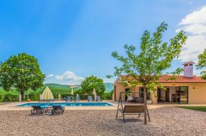um quintal com um baloiço e uma piscina em Villa Patria with Media room, Private pool, Summer kitchen, Gym em Lovreć