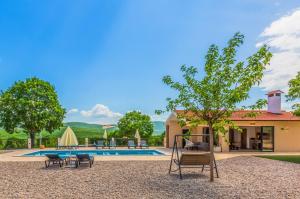 a backyard with a swing and a pool at Villa Patria with Media room, Private pool, Summer kitchen, Gym in Lovreć