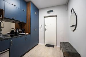 eine Küche mit blauen Schränken und einer weißen Tür in der Unterkunft Blvd Ivory Pipera ap.70A in Bukarest