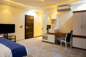 a bedroom with a bed and a desk and a television at HOTEL ALFAW PLAZA in Sharurah