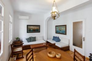a living room with a table and a couch at Esperos Apartment in Skopelos Town