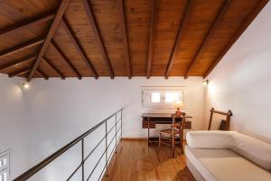 a living room with a couch and a piano at Esperos Apartment in Skopelos Town