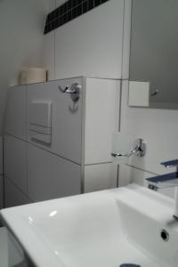 Baño blanco con lavabo y espejo en Resort Bobrovník, en Lipová-lázně