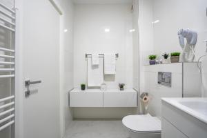 ein weißes Badezimmer mit Toilette und Waschbecken in der Unterkunft Blvd Ivory Pipera ap.70A in Bukarest + 36 Fotos