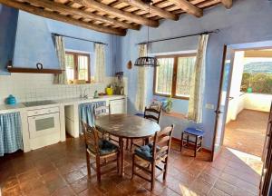 a kitchen with a table and chairs in a room at Casa Rural El Chorrillo Cazalla de la Sierra in Cazalla de la Sierra