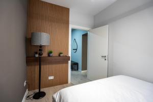 ein Schlafzimmer mit einem Bett, einer Lampe und einer Tür in der Unterkunft Blvd Ivory Pipera ap.70A in Bukarest