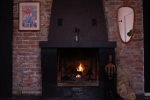 a brick fireplace with a fire in it at Charming apartment in central Stavanger in Stavanger