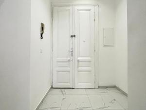 a white door in a white room with a tile floor at Premium Residence at famous Vienna Kutschkermarkt in Vienna