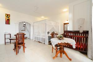 Habaraduwa CentralにあるVilla Jungle & Wienerのテーブル、椅子、ベッドが備わる客室です。