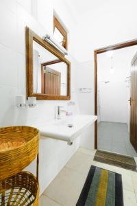 ein Bad mit einem Waschbecken und einem Spiegel in der Unterkunft Villa Jungle & Wiener in Habaraduwa Central