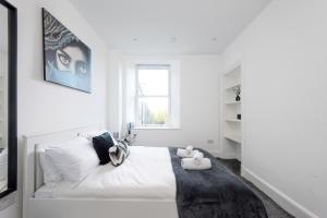 Un dormitorio blanco con una gran cama blanca y una ventana en Spectacular View City Centre Haven en Edimburgo