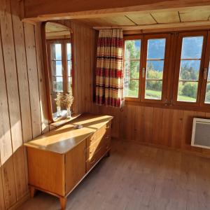 ein Bad mit einer Badewanne und Fenstern in einer Hütte in der Unterkunft Meieli's Chalet in Hofstetten 