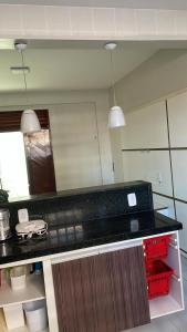 une cuisine avec un comptoir noir et deux lumières dans l'établissement Ed Carlos alberto, à Cabedelo
