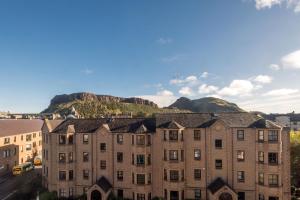 un edificio de apartamentos con una montaña en el fondo en Spectacular View City Centre Haven en Edimburgo
