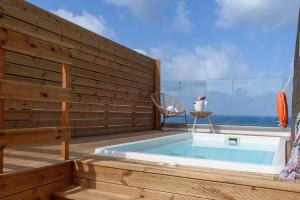 uma banheira de hidromassagem sentada num deque com o oceano em Eurohotel Theo Hotel em Agia Marina Nea Kydonias