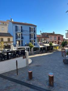 una plaza de la ciudad con mesas y sillas y un edificio en Hôtel de la Corniche d'Or en Mandelieu-la-Napoule