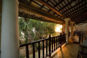 eine Veranda eines Hauses mit einem Zaun und Bäumen in der Unterkunft Villa Jungle & Wiener in Habaraduwa Central