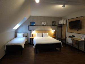 Habitación de hotel con 2 camas y TV en ibis Creil Sur Oise, en Villers-Saint-Paul
