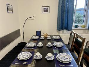 una mesa de comedor con platos azules y blancos. en Apartmán "U nás doma" v chatě ALFA Černý Důl, en Černý Důl