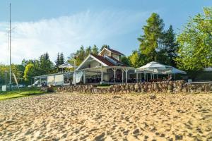 ein Gebäude an einem Sandstrand neben einem Haus in der Unterkunft Piękny Brzeg in Angerburg