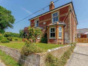 a brick house with a stone wall in front of it at 2 bed property in Ventnor 82973 in Wroxall