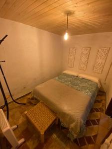 a small room with a bed and a bench in it at La Casita Encendida in Villamayor de Campos