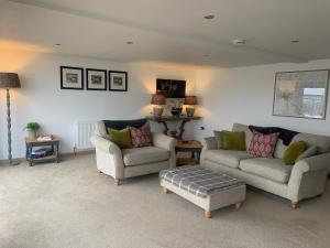 Sala de estar con 2 sofás y mesa en 1 bed property in Stowmarket 83463 en Mendlesham