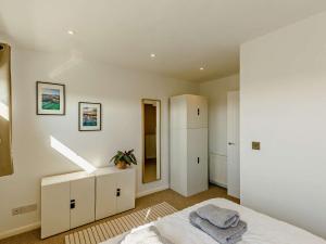 a white bedroom with a bed and a mirror at 2 bed in Brixham 83741 in Brixham