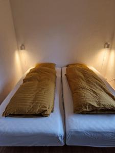 a bed with two pillows on it in a room at Lille bo in Silkeborg